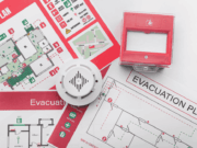 Is It Time To Update Your Emergency Action Plan? Emergency Action Plan document open on a desk, showing clear headings, contact lists, and venue maps with AED and EMS access points highlighted, representing an athletic department’s preparedness and commitment to safety.