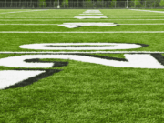 A Back-to-School and Fall Sports Preparation Checklist for Athletic Directors view of a football and soccer field under bright summer sun, freshly painted lines visible—symbolizing preparation for the fall sports season.