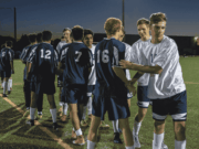 The Decline of Sportsmanship in Scholastic Athletics Two high school athletes from opposing teams shake hands after a game, embodying a moment of sportsmanship amid growing concerns about declining respect and behavior in competitive athletics.