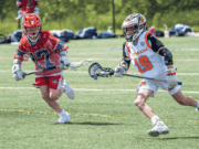 How to Successfully Add a New Sport to Your School’s Athletic Program High school lacrosse players in full gear sprint across a green field during practice, showcasing the sport’s growing popularity as part of a school’s expanding athletic program.