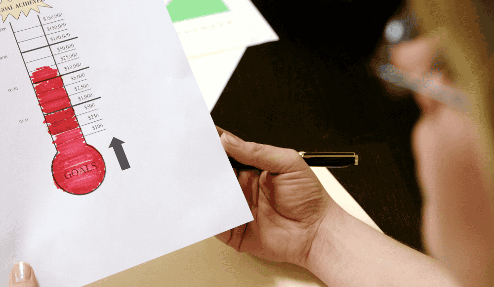 10 Creative Fundraising Ideas That Actually Work for Athletics Programs A red fundraising thermometer graphic showing progress toward a donation goal. The rising bar symbolizes money raised, representing community support and successful athletics fundraising.