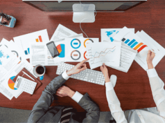 The 5 Metrics That Show True Program Health Athletic administrators reviewing performance charts and data at a desk, representing key metrics like participation, retention, GPA, injuries, and engagement that show overall athletic program health.