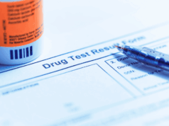 Is Drug Testing a Liability? Drug testing form with prescription bottle and pen, representing student-athlete drug testing policies, legal risk, and compliance issues in high school athletics.